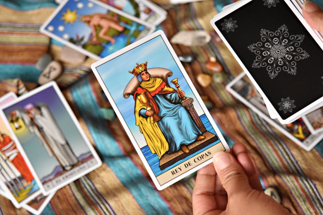 Close-up of a person holding a tarot card during a lively divination session.