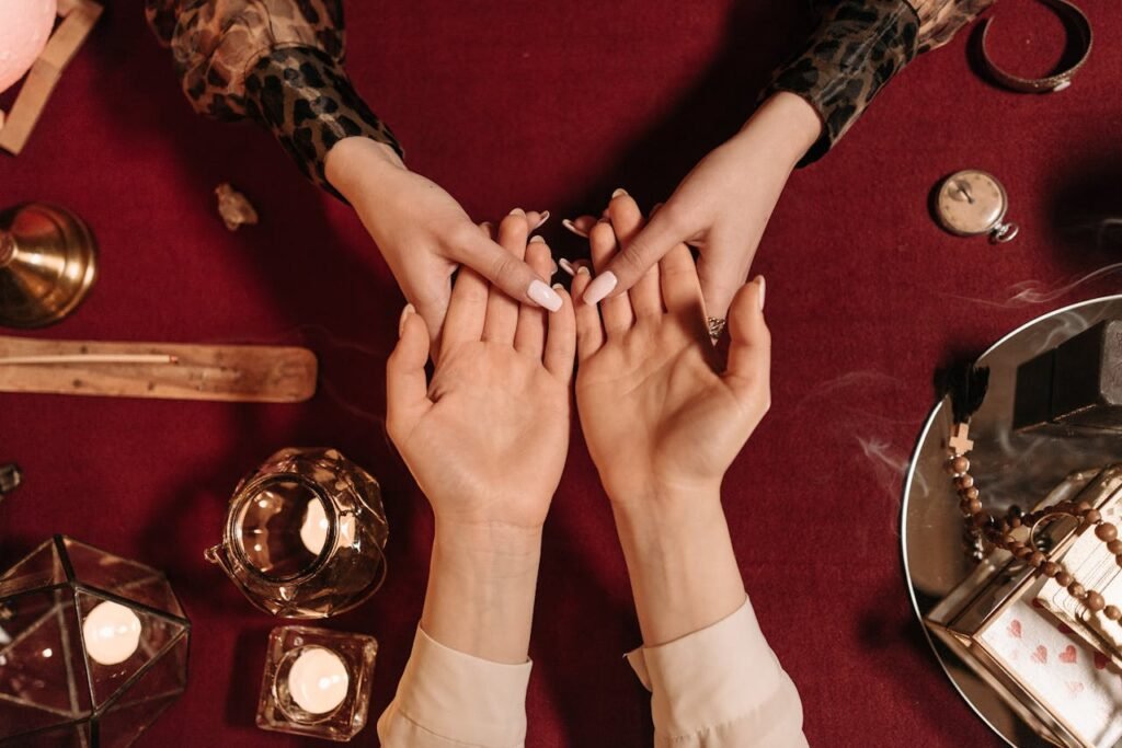 Top-down view of a mystical palm reading session with candles and spiritual objects.